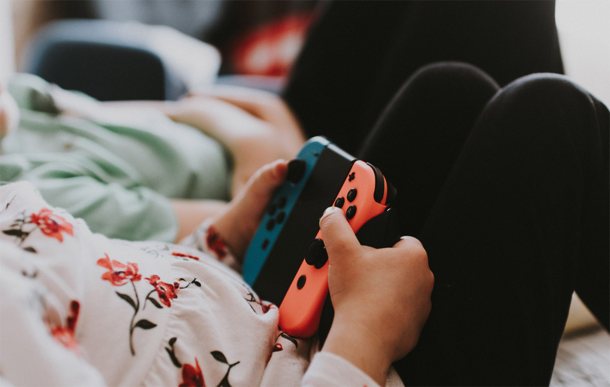 child holding Nintendo Switch controller child holding Nintendo Switch controller
