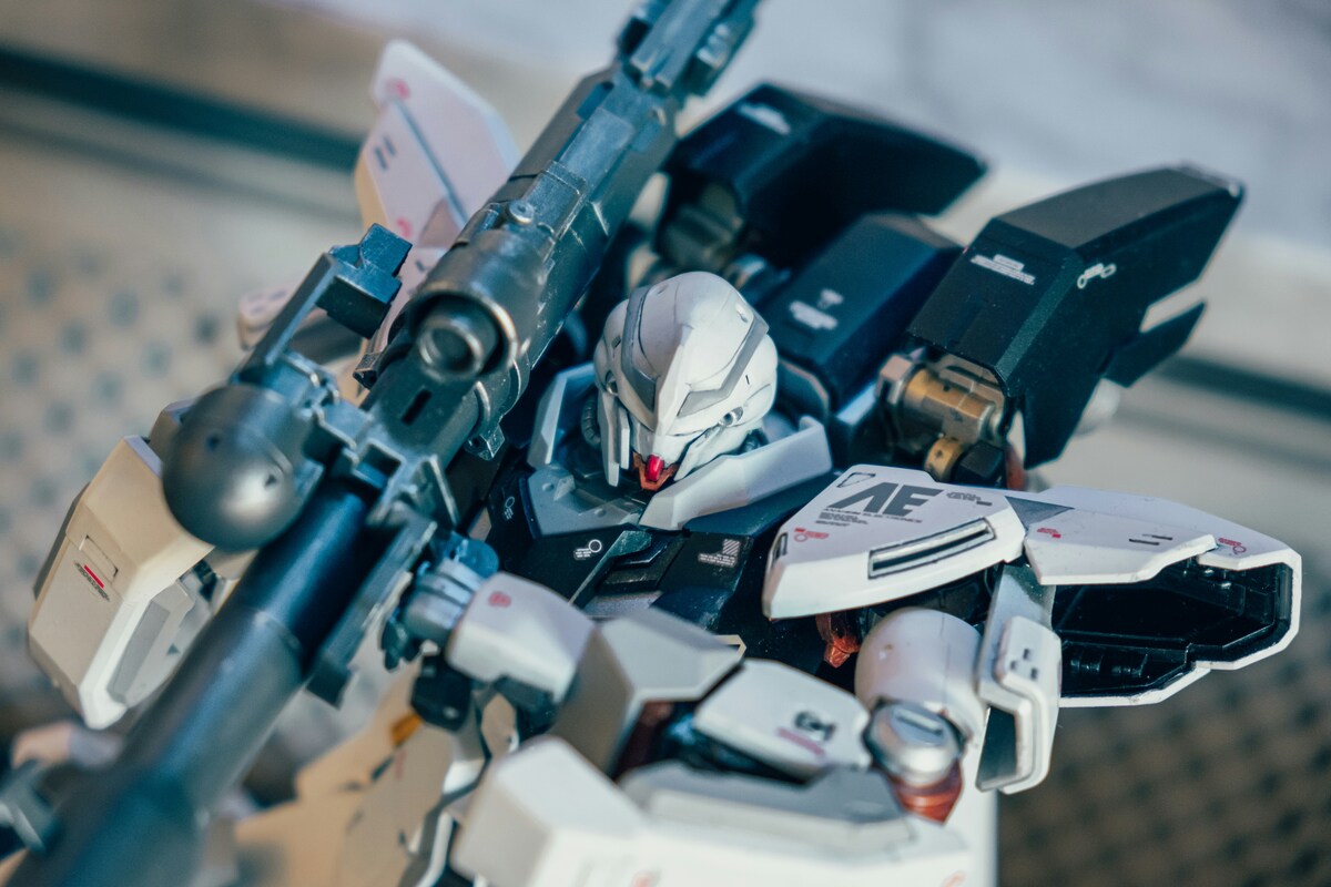 Close-up of a finished Gundam with decals and metallic-looking weapon Close-up of a finished Gundam with decals and metallic-looking weapon