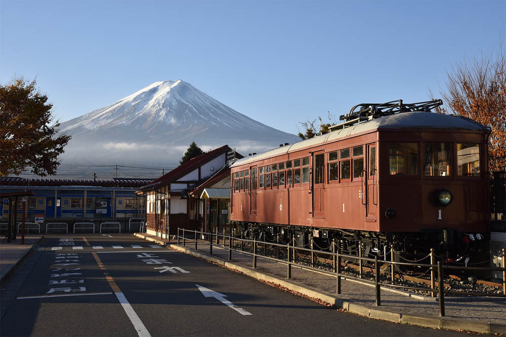 Mount Fuji with a Japanese railroad system in the foreground, complete with train and station of traditional design Mount Fuji with a Japanese railroad system in the foreground, complete with train and station of traditional design