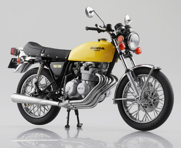 A retro-style Honda motorcycle in yellow, with cylinders