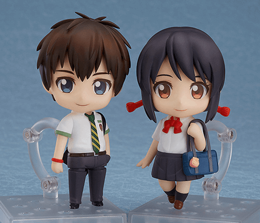 Standing male and female Chibi-style anime figurines on clear stands with a grey backdrop. Standing male and female Chibi-style anime figurines on clear stands with a grey backdrop.