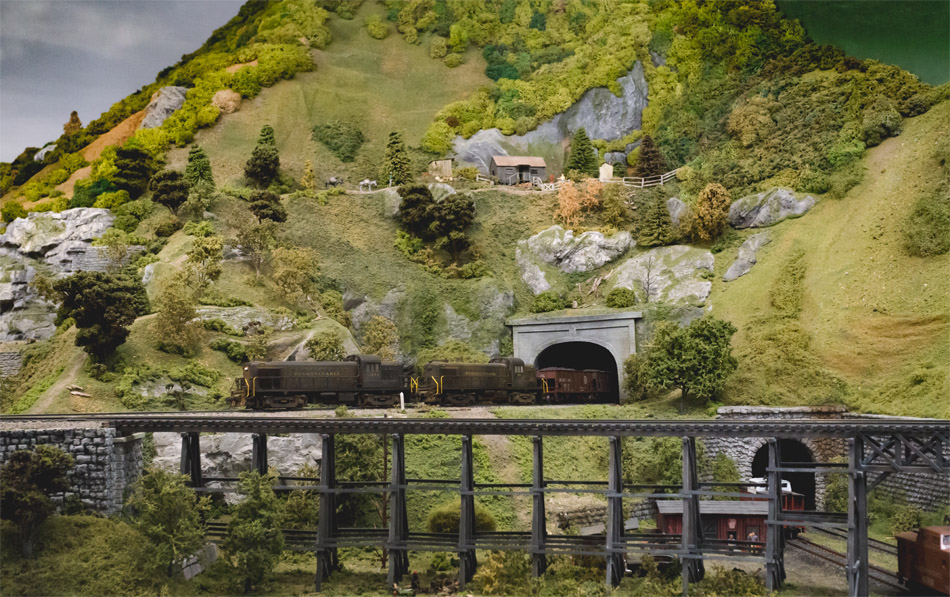 A picture of a model train going into a tunnel. A picture of a model train going into a tunnel.