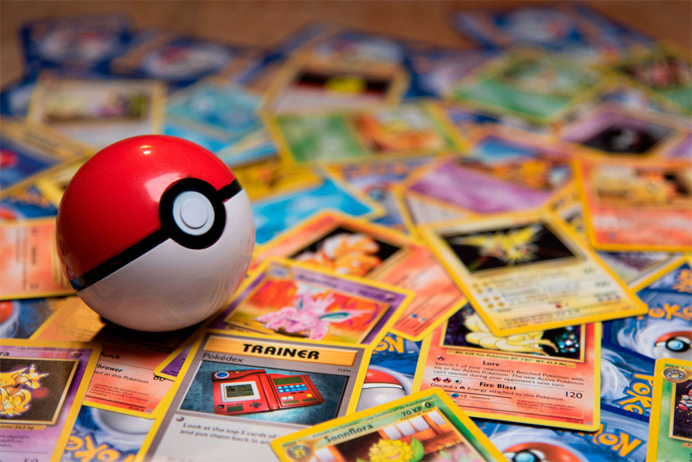 a pokeball on top of a pile of pokemon cards a pokeball on top of a pile of pokemon cards