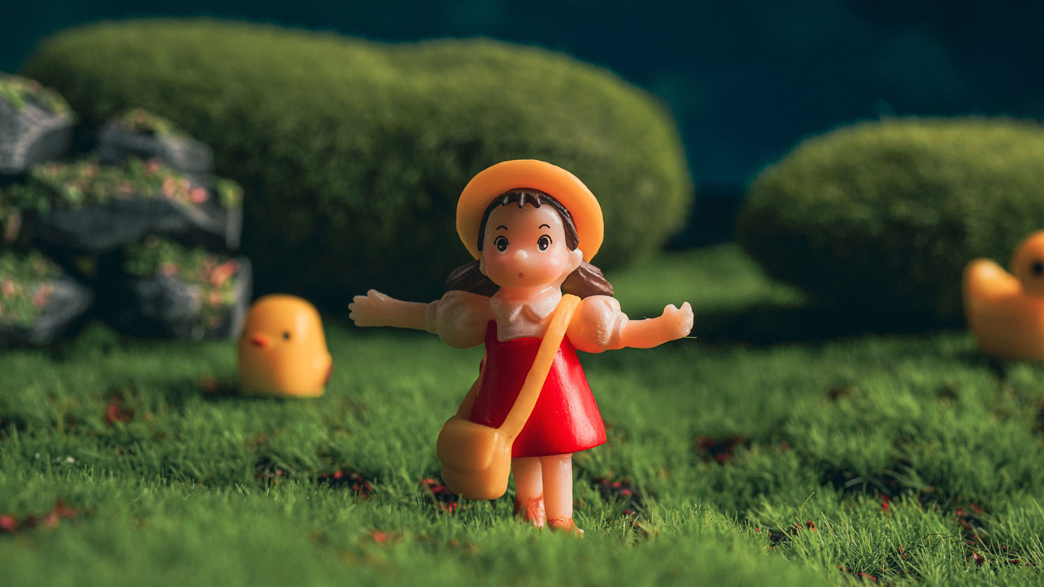 A Studio Ghibli Mei Kusakabe figurine on grass A Studio Ghibli Mei Kusakabe figurine on grass